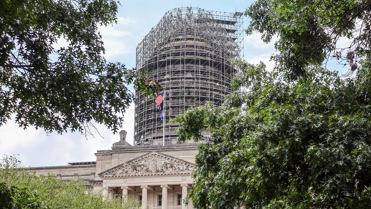 Trees at Kentucky's Capitol with the Capitol building and scaffolding in the background.